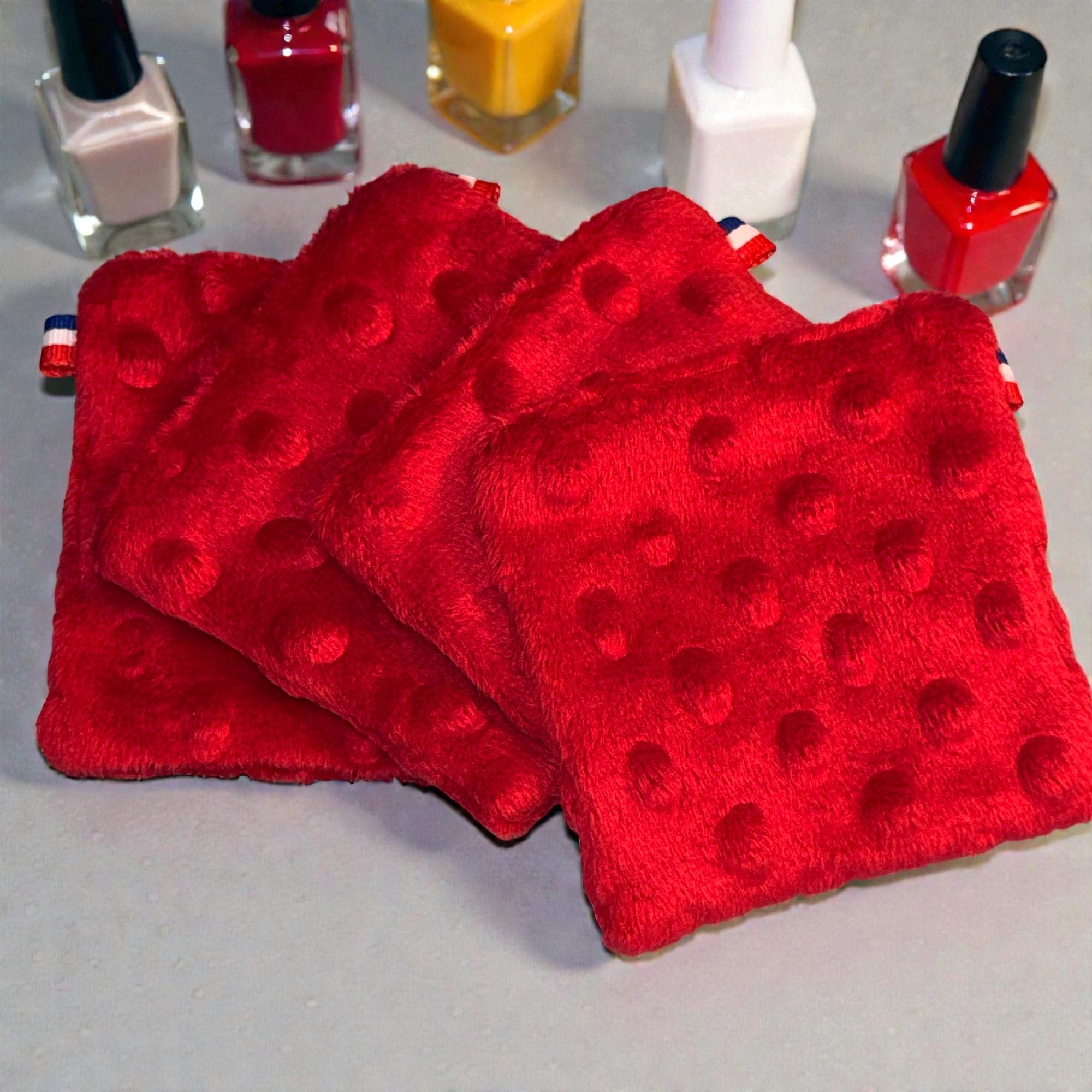 4 cotons lavables pour le retrait des vernis avec autour des vernis. Ces lingettes sont fabriquées en france par Moonlac et sont faciles à mettre dans la valise quand vous voyagez afin de rester éco-responsable et zéro déchet