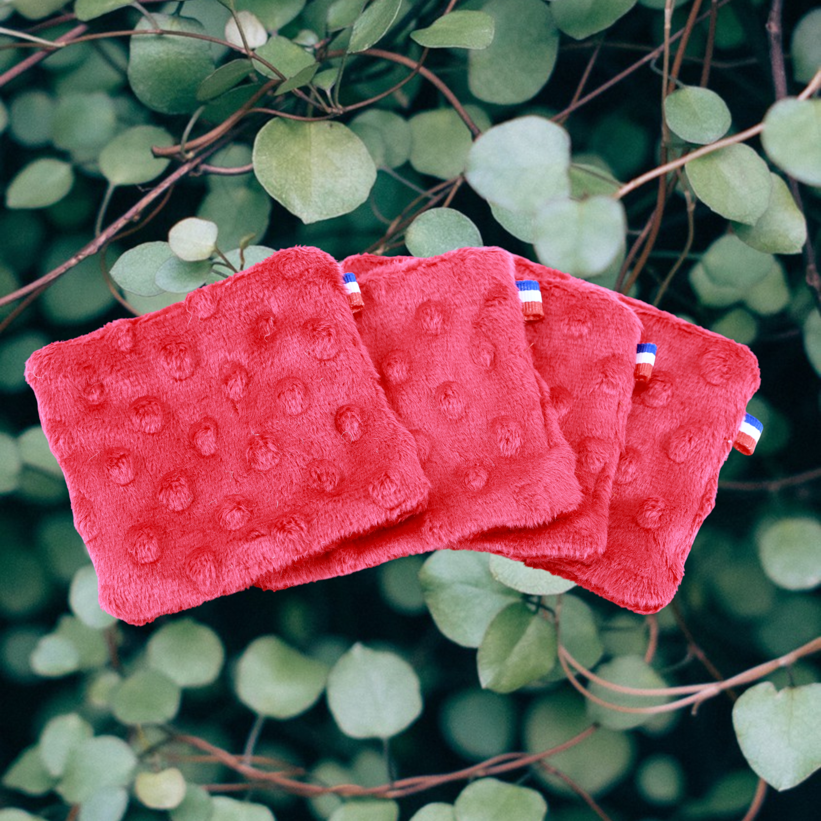 Coton lavable spécial vernis à ongles. Fabriqués en France par Moonlac. Les Cotons sont posés sur des feuilles vertes  
