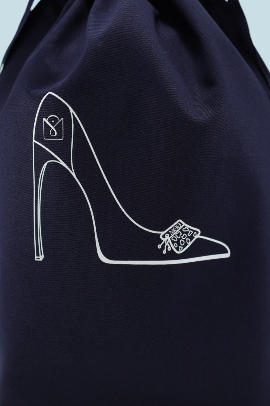 Pochon Moonlac en coton bleu marine debout, sérigraphie en blanc d'escarpins et de pierres posées sur le devant de la chaussures