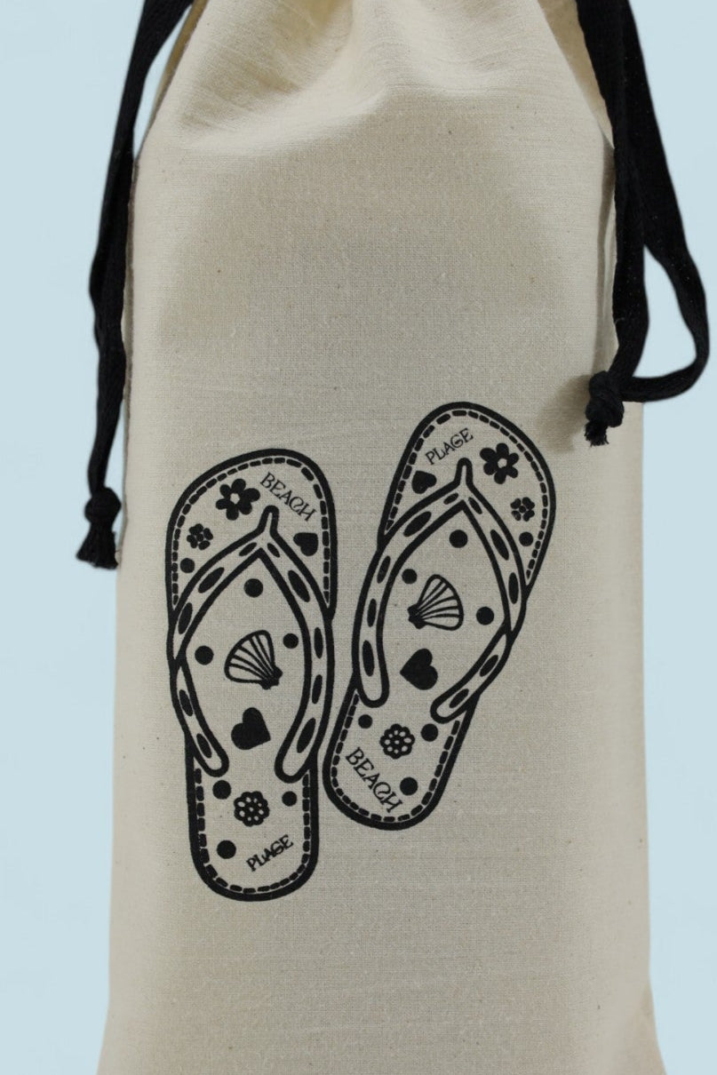 Pochon étroit Moonlac en coton écru, sérigraphié de tongs avec motifs et texte “BEACH / PLAGE”, cordons noirs, posé debout