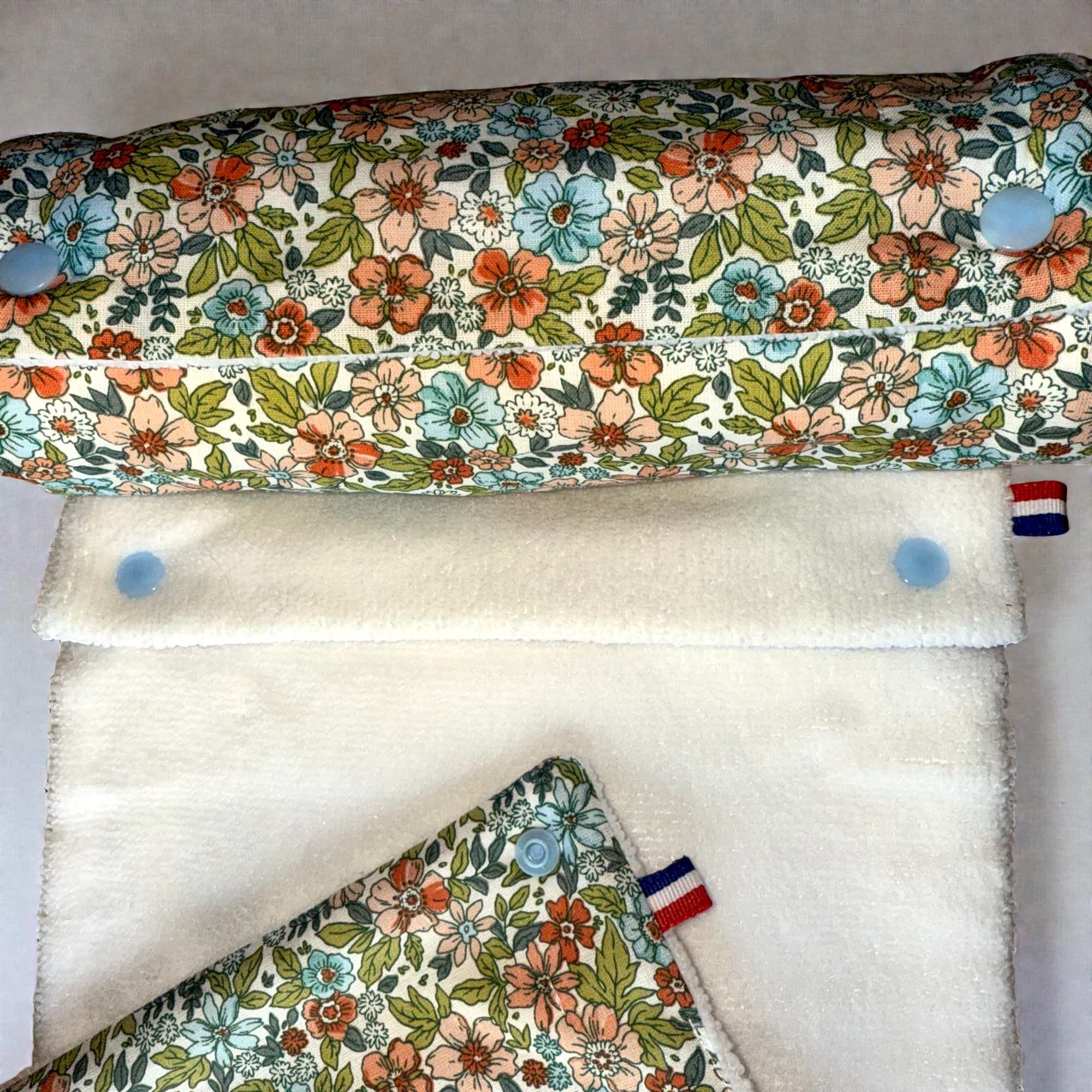 Gros plan du rouleau d'essuie-tout lavable Fleurs vertes Moonlac avec des pressions bleu ciel